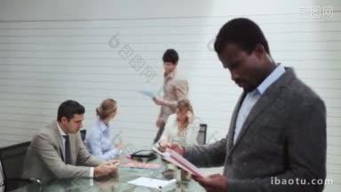 黑人商人的肖像与团队的人在工作和谈话在会议室的背景会议